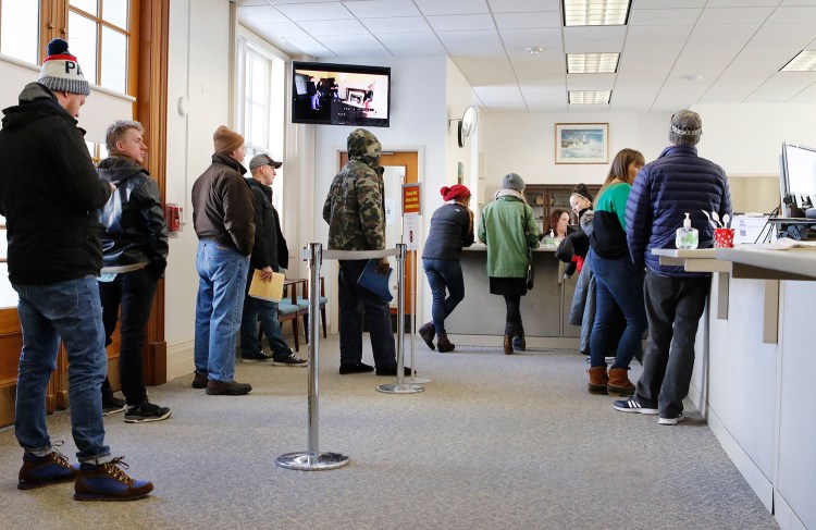 Residents wait in line Thursday at Portland City Hall to pay property tax bills or register vehicles. But many municipalities, including Portland, are not accepting prepayments for taxes that have yet to be assessed on properties.