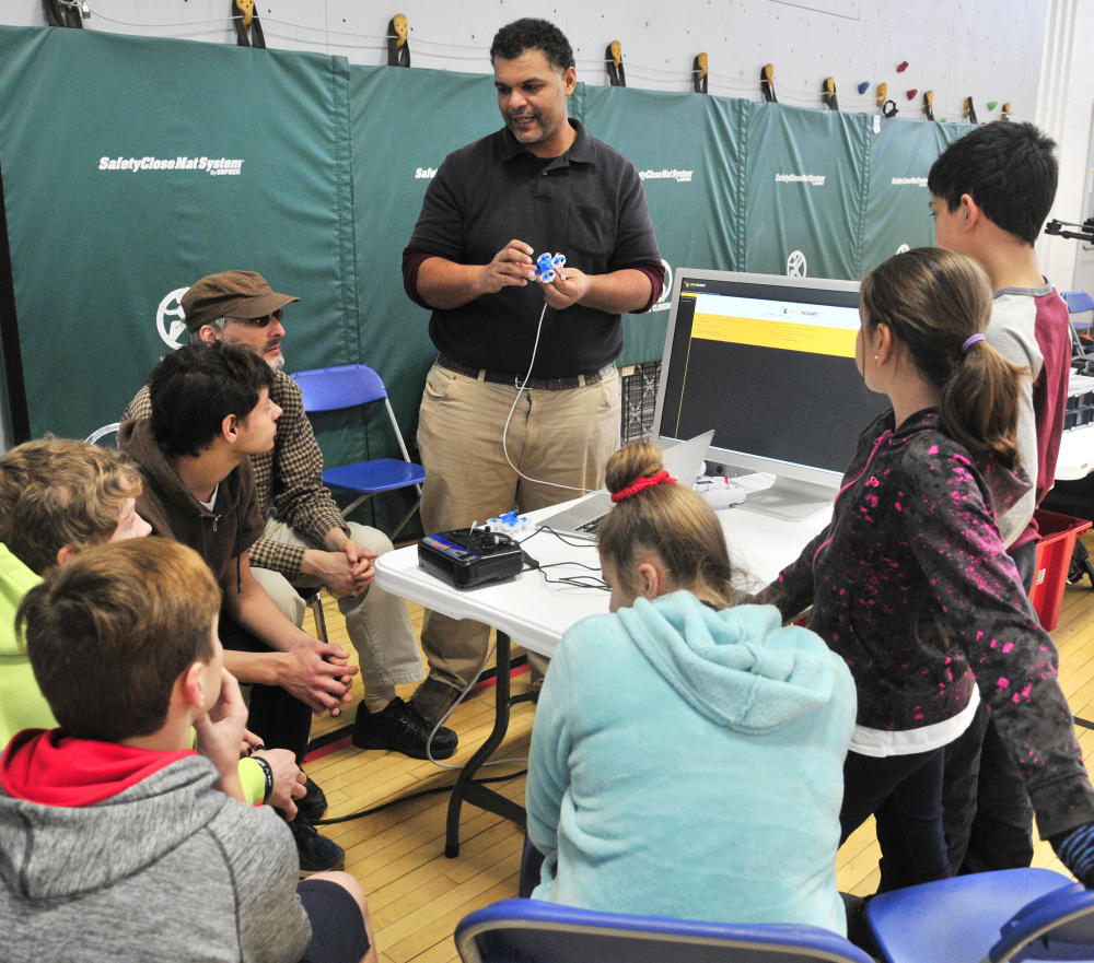 Kristopher Kleva holds a small drone as he talks about how to program the guidance system on the computer during a demonstration for Augusta Boys and Girls Club on Friday at The Buker Center in Augusta.