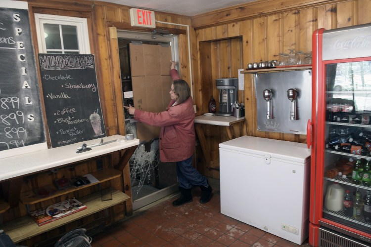 The Hi-Hat Pancake House manager Mary Laflin replaces cardboard on a door that was shattered early Tuesday when the Farmingdale restaurant was broken into. An ATM machine was stolen.