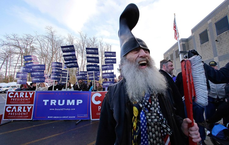 Democratic presidential candidate Vermin Supreme smiles while holding a giant toothbrush and wearing  a boot on his head while visiting a polling station on 2016 primary day during a campaign stop in Londonderry, N.H. Supreme sued the state capital, saying its denial of his request to bring two ponies to his planned protest of Hillary Clinton's book signing, scheduled for Tuesday, violates the First Amendment.