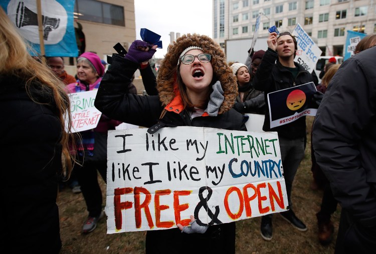 Lindsay Chestnut of Baltimore holds a sign that reads "I like My Internet Like I Like my Country Free & Open" as she protests near the Federal Communications Commission Thursday in Washington.