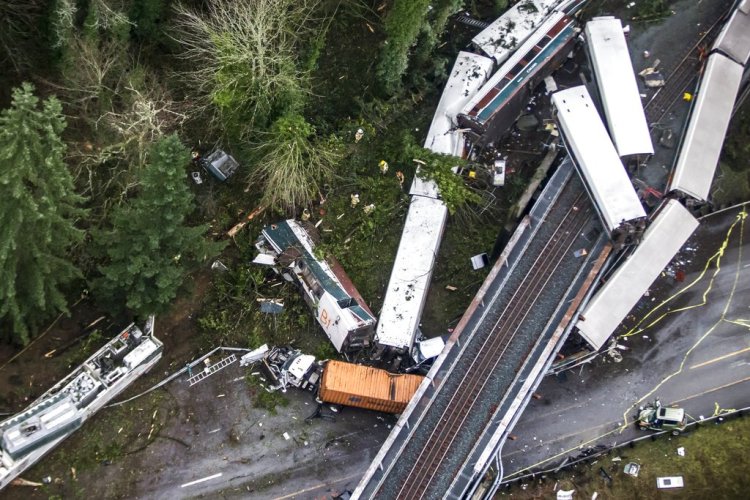 Train cars lie where they spilled onto Interstate 5 Monday,  in DuPont, Wash. The Amtrak train was making its first-ever run along a faster new route when it hurtled off the overpass.