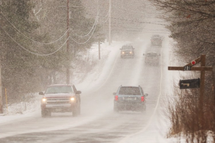 Motorists navigate heavy snowfall late Friday morning on Route 22 in Gorham.