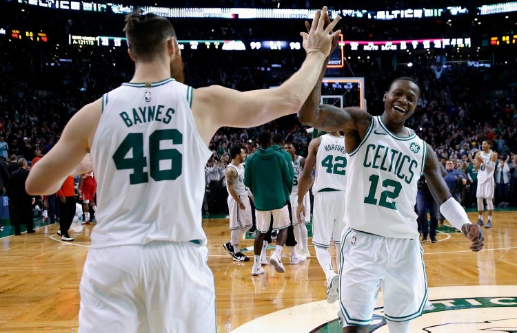 Boston’s Terry Rozier, 12, and Marcus Smart celebrate after defeating the Houston Rockets Thursday night in Boston. Smart drew two offensive fouls against James Harden in the closing seconds to help Boston complete the comeback.