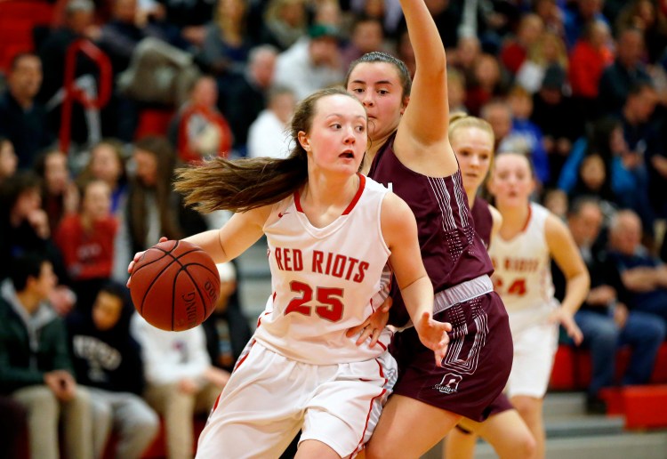 South Portland's Maggie Whitmore looks to pass while Greely's Emma Spoerri defends. Whitmore was the leading scorer for South Portland with 22 points, 19 in the second half.  The Red Riots won 63-53.