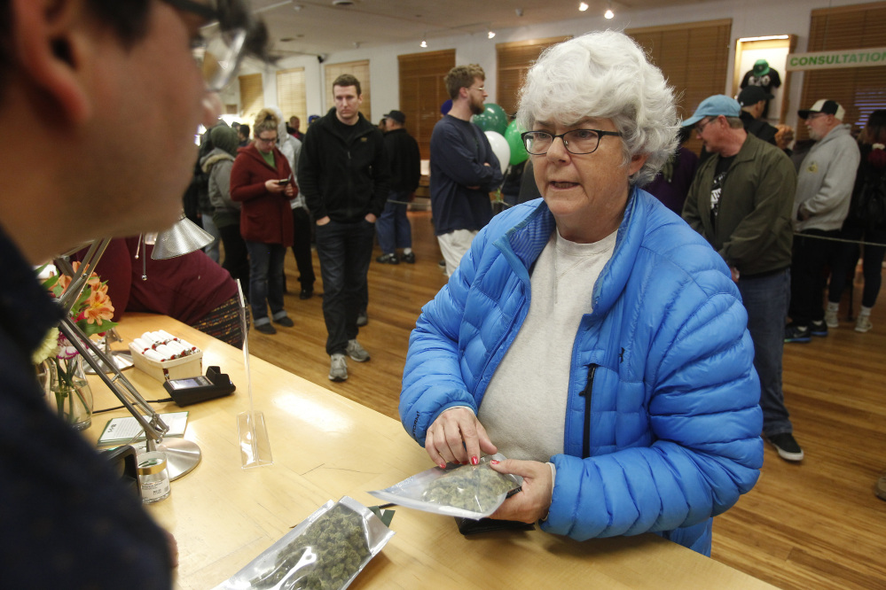 Margot Simpson purchases marijuana at Harborside marijuana dispensary Monday in Oakland, Calif. The dispensary offered early customers joints for a penny.