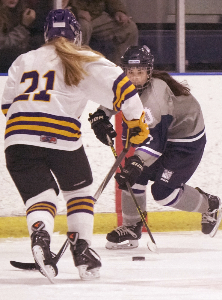 Emma Merrill of Portland/Deering looks for an opening against Abby Enck of Cheverus/Kennebunk during the City Cup girls' hockey game Monday at Troubh Ice Arena. Portland knocked off the previously undefeated Stags, 4-3 in overtime.