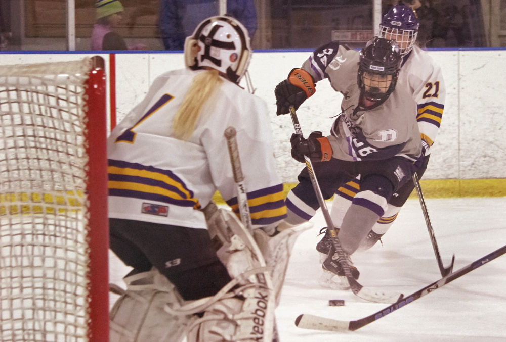 Emily Demers of Portland/Deering prepares to shoot against Cheverus/Kennebunk goalie Anna Smith. Demers scored a third-period goal to help the Bulldogs pull out a 4-3 overtime victory.