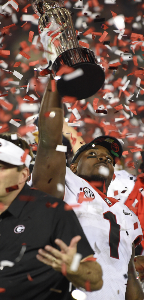 Georgia running back Sony Michel holds the Rose Bowl trophy Monday after scoring the overtime touchdown that beat Oklahoma 54-48 and put the Bulldogs into the final against Alabama.