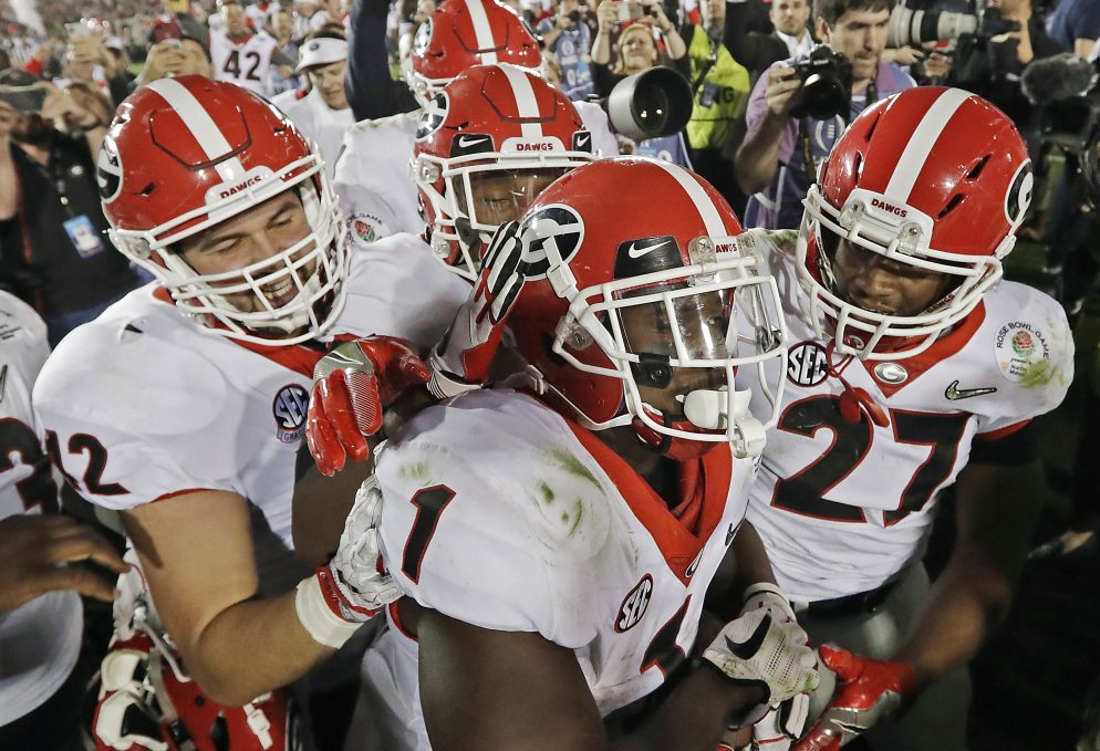 The Bulldogs were celebrating Monday night after Sony Michel, 1, scored the winning touchdown in the second overtime to give Georgia a 54-48 win over Oklahoma in the Rose Bowl. The Bulldogs must regroup and focus quickly because they are playing Alabama for the national title Monday night.