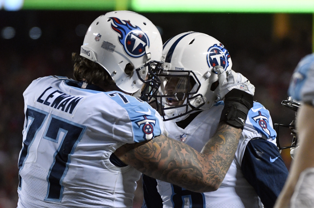 Tennessee offensive tackle Taylor Lewan congratulates quarterback Marcus Mariota after Mariota scored on a pass to himself Saturday. Mariota caught a tipped pass and made it to the end zone in a 22-21 win over Kansas City.