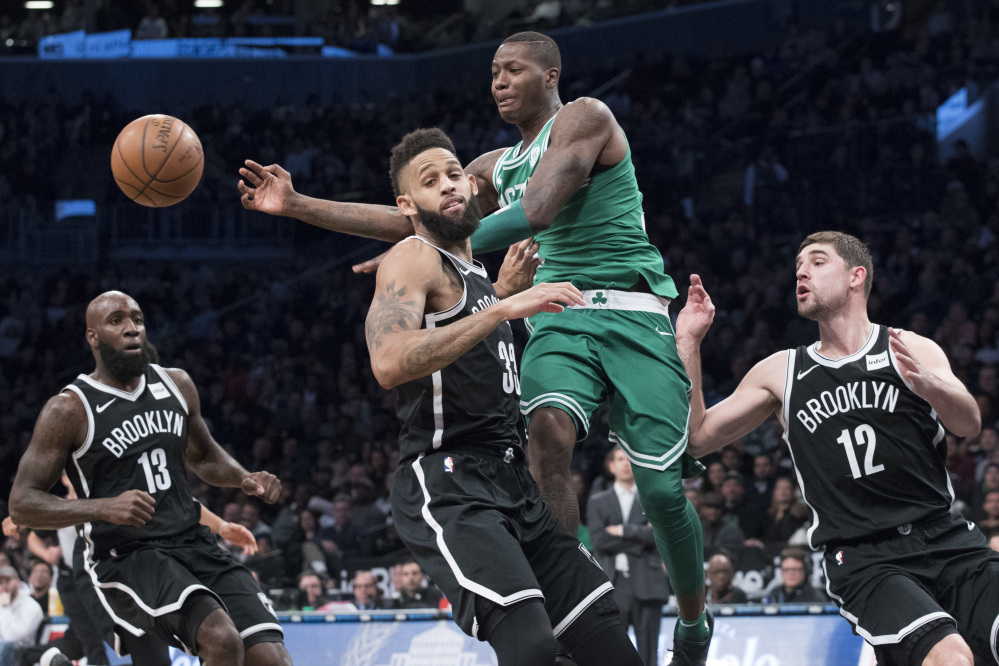 Boston Celtics guard Terry Rozier, center, moves the ball around Brooklyn Nets guard Allen Crabbe (33) during the second half of an NBA basketball game Saturday, Jan. 6, 2018, in New York.