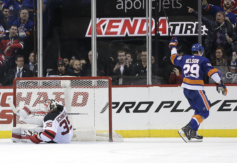 The Islanders' Brock Nelson, right, reacts after scoring the winning shootout goal against Devils goaltender Cory Schneider in New York's 5-4 victory at home Sunday.