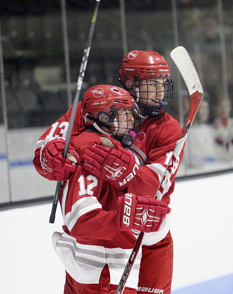Aidan Schifano, left, celebrates with South Portland/Freeport/Waynflete teammate Devan Hannan after the first of Schifano's two goals Monday.