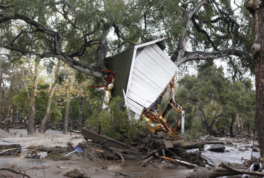 A structure is smashed against a tree along Hot Springs Road in Montecito, California, after getting hit by a flash flood and debris on Tuesday. Several homes were swept away before dawn Tuesday when mud and debris roared into neighborhoods in Montecito from hillsides stripped of vegetation during a recent wildfire.