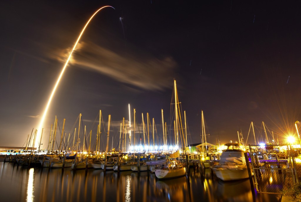In this image made with an 8-minute exposure, the SpaceX Falcon 9 rocket launches from Cape Canaveral Air Force Station and lands as seen from from the Ocean Club Marina in Port Canaveral, Fla., Sunday.