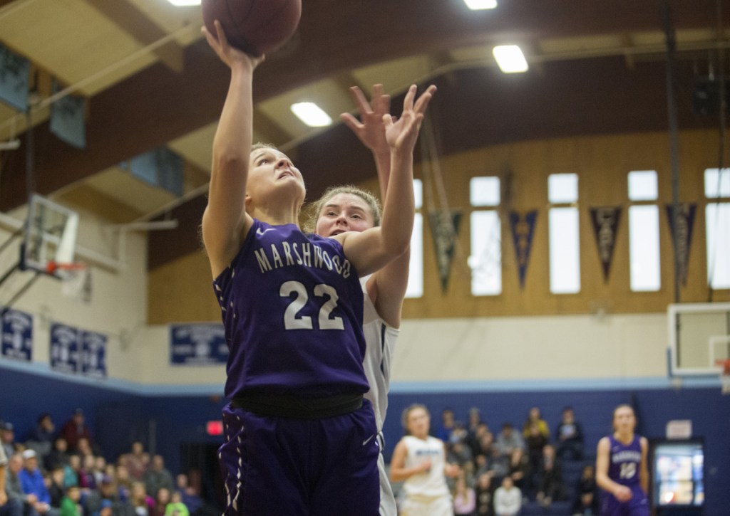 Marshwood's Elora Montgomery drives to the basket against Kristen Leroux of York and makes a layup during her team's 35-27 win Saturday afternoon in York.