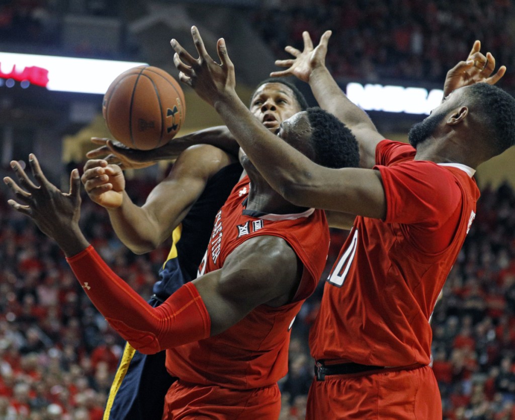 Sagaba Konate of West Virginia, left, competes for a rebound with Norense Odiase, center, and Niem Stevenson of Texas Tech during the second half of Texas Tech's 72-71 victory Saturday. Texas Tech was ranked No. 8 and West Virginia was No. 2.