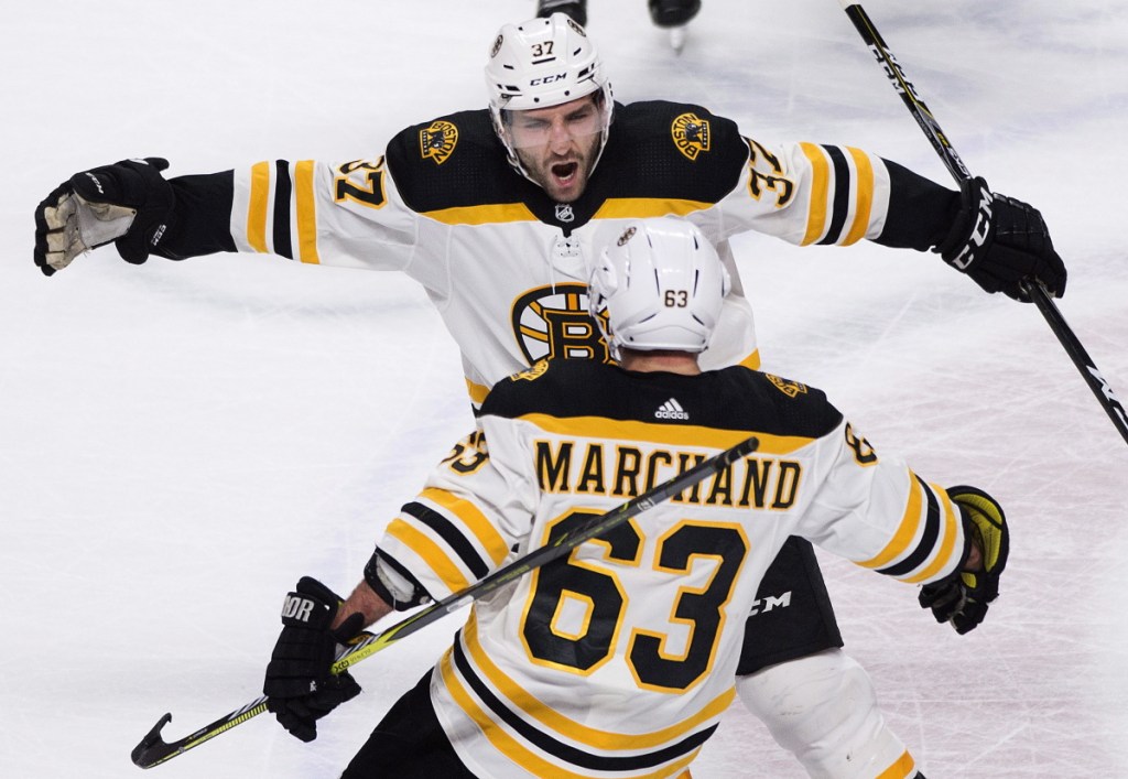 Boston Bruins' Brad Marchand (63) celebrates with teammate Patrice Bergeron after scoring against the Montreal Canadiens during the shootout in NHL hockey action in Montreal, Saturday, Jan. 13, 2018. (Graham Hughes/The Canadian Press via AP)