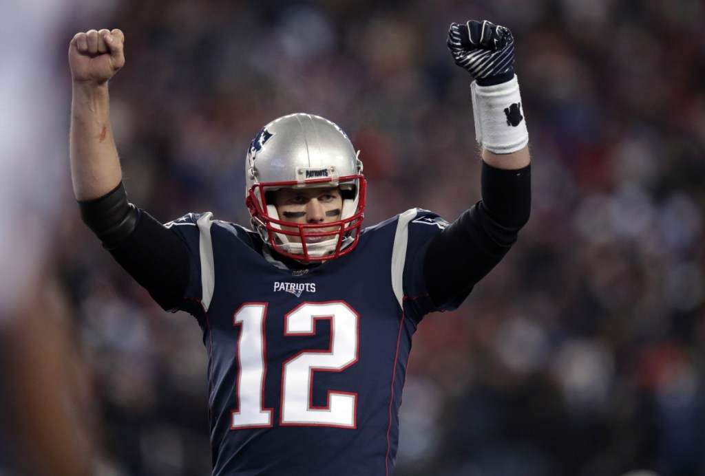 New England quarterback Tom Brady celebrates a touchdown by James White in the first half of Saturday's divisional playoff football game against Tennessee, in Foxborough, Mass.