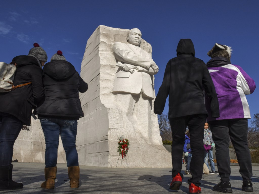 People gather at the Martin Luther King Jr. Memorial on the National Mall on Saturday. Monday's holiday honors the civil rights leader assassinated nearly 50 years ago.