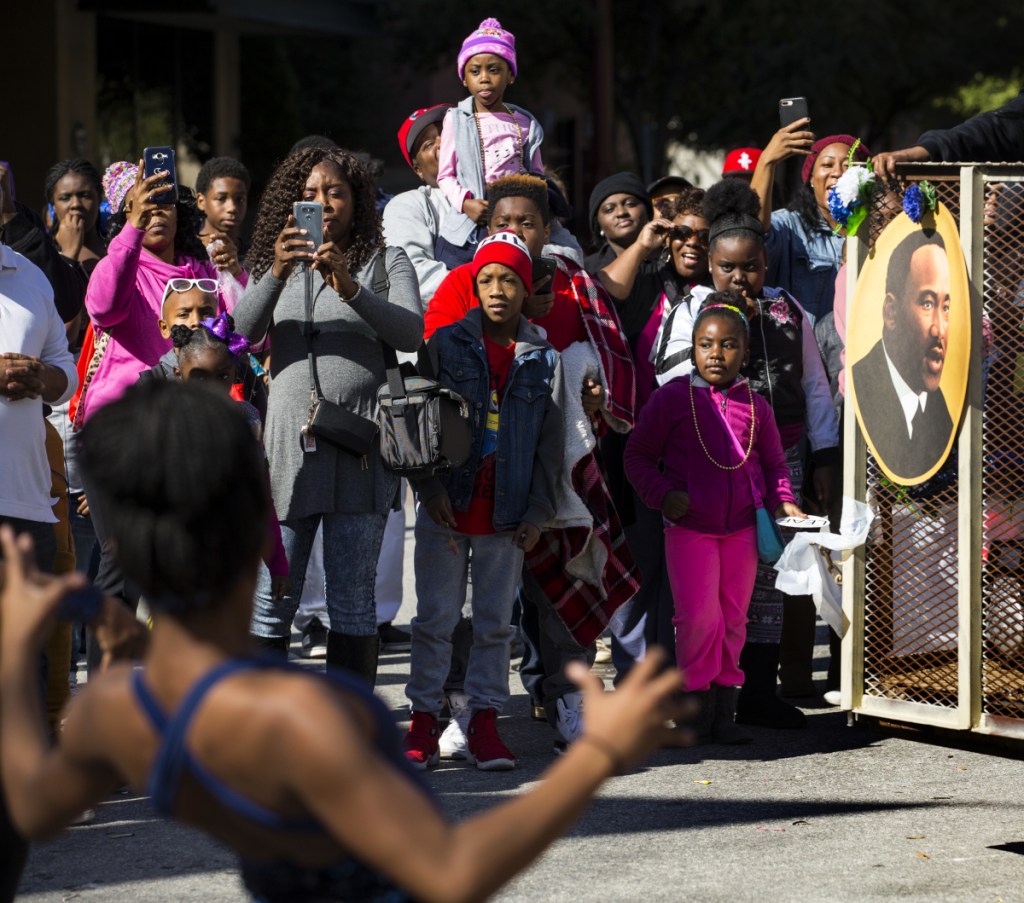 People watch a parade honoring slain civil rights leader the Rev. Martin Luther King Jr., on Monday in Houston.
