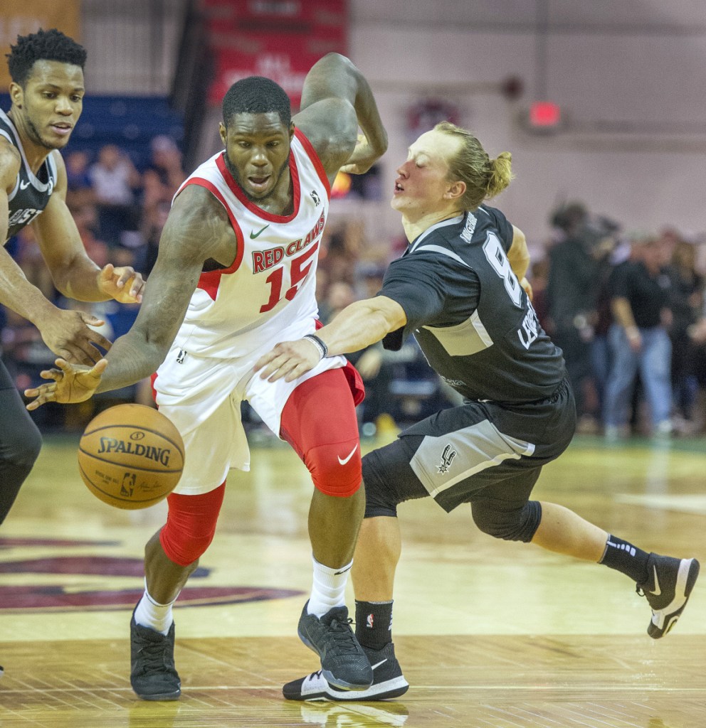 Maine's Anthony Bennett pushes the ball upcourt ahead of Austin's Jeff Ledbetter in Monday night's game at the Portland Expo.