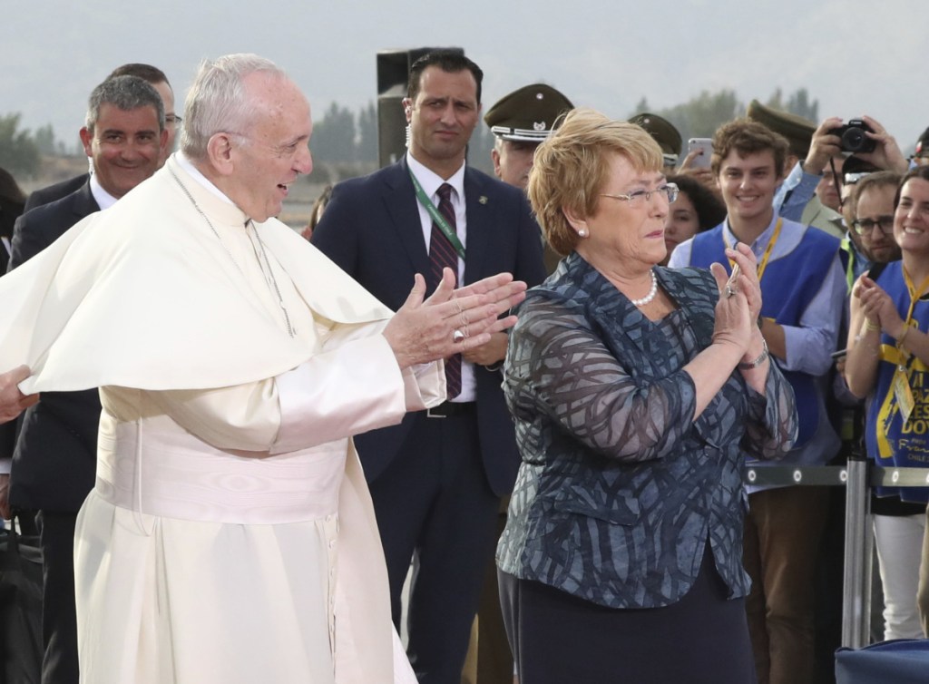 Pope Francis and Chile's President Michelle Bachelet applaud a group of young musicians as he arrives at the international airport in Santiago, Chile, on Monday.