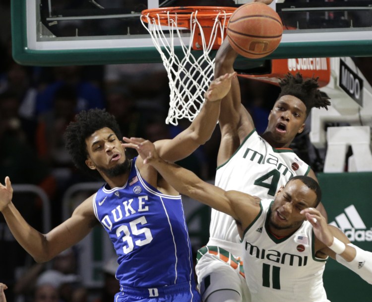 Duke's Marvin Bagley III, Miami's Lonnie Walker IV, 4, and Bruce Brown Jr., 11, all fight for a rebound during the Blue Devils' 83-75 win Monday in Coral Gables, Florida.