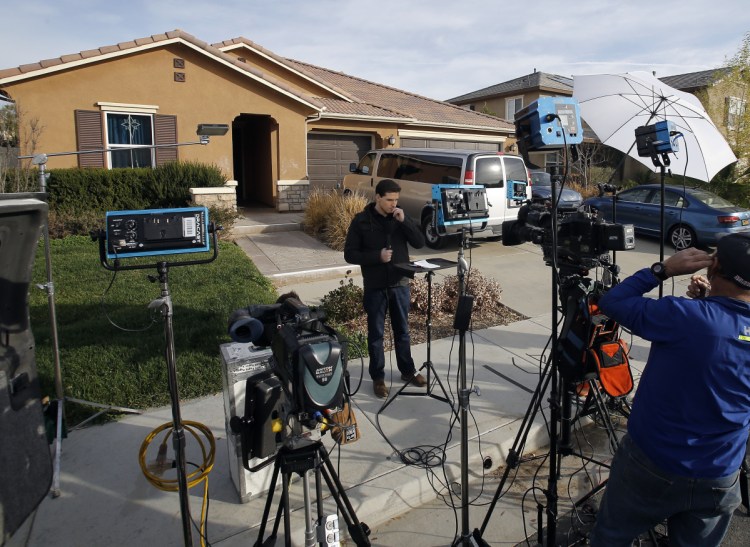 Members of the media work Tuesday outside a home in Perris, Calif., where police on Sunday arrested a couple accused of holding 13 children captive in filthy conditions.