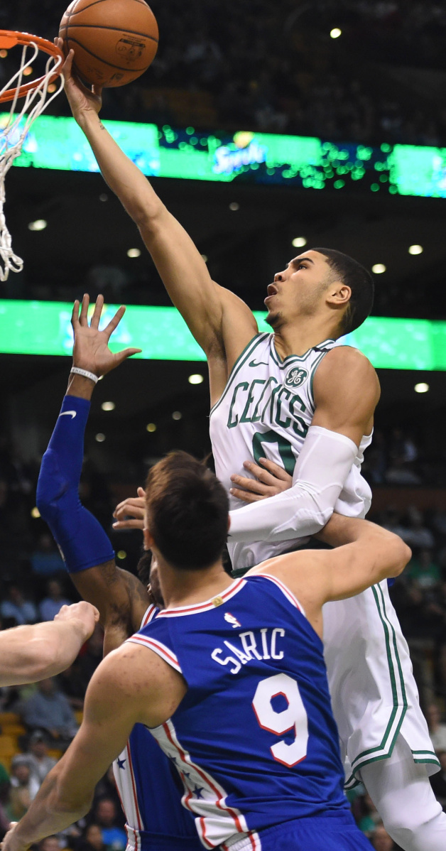 Jayson Tatum of the Boston Celtics lays the ball up in front of Dario Saric of the Philadelphia 76ers during the first half of Philadelphia's 89-80 victory Thursday night in Boston.