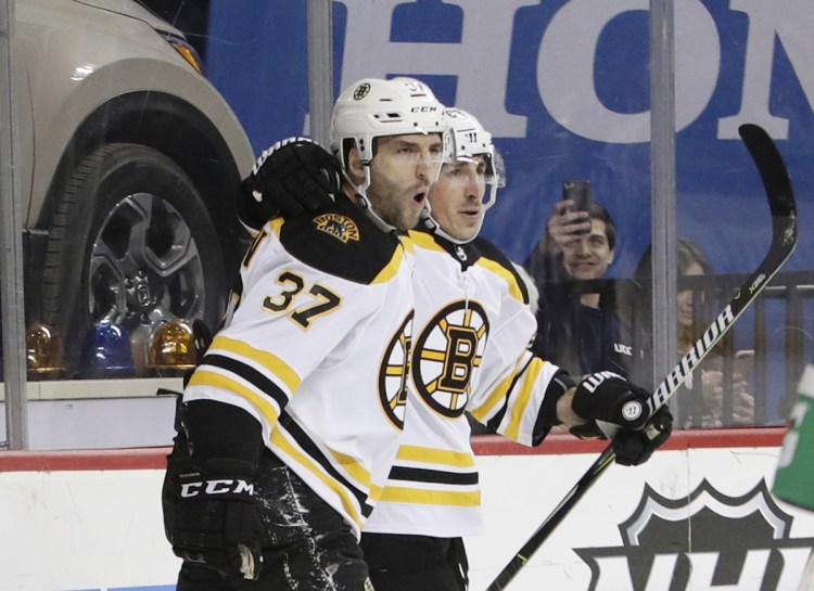 Boston's Patrice Bergeron, 37, celebrates with Brad Marchand after scoring a goal in the first period Thursday night in Brooklyn.