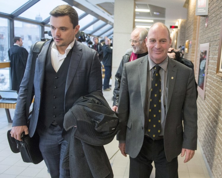 Train driver Thomas Harding leaves the courtroom with his lawyers Charles Shearson, left, and Tom Walsh, rear, after being found not guilty on the ninth day of deliberations Friday in Sherbrooke, Quebec. One of the most closely watched Canadian trials in recent years ended Friday with the acquittal of three former railway employees who were charged with criminal negligence in the death of 47 people in the Lac-Megantic tragedy.