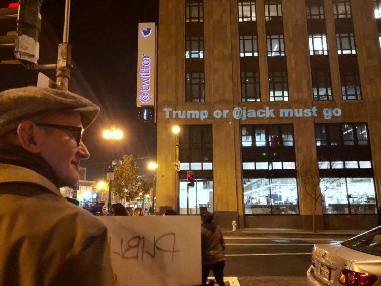 Protesters gather outside Twitter's headquarters in San Francisco, and project messages on the building. 