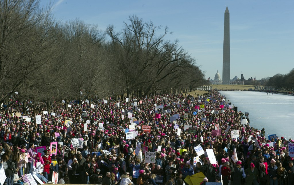 Women's March demonstrators line the Reflecting Pool at the Lincoln Memorial  with the Capitol and Washington Monument in the background in Washington on Saturday.  Activists are returning to the streets a year after millions of people rallied worldwide at marches for female empowerment, hoping to create an enduring political movement that will elect more women to government office.
