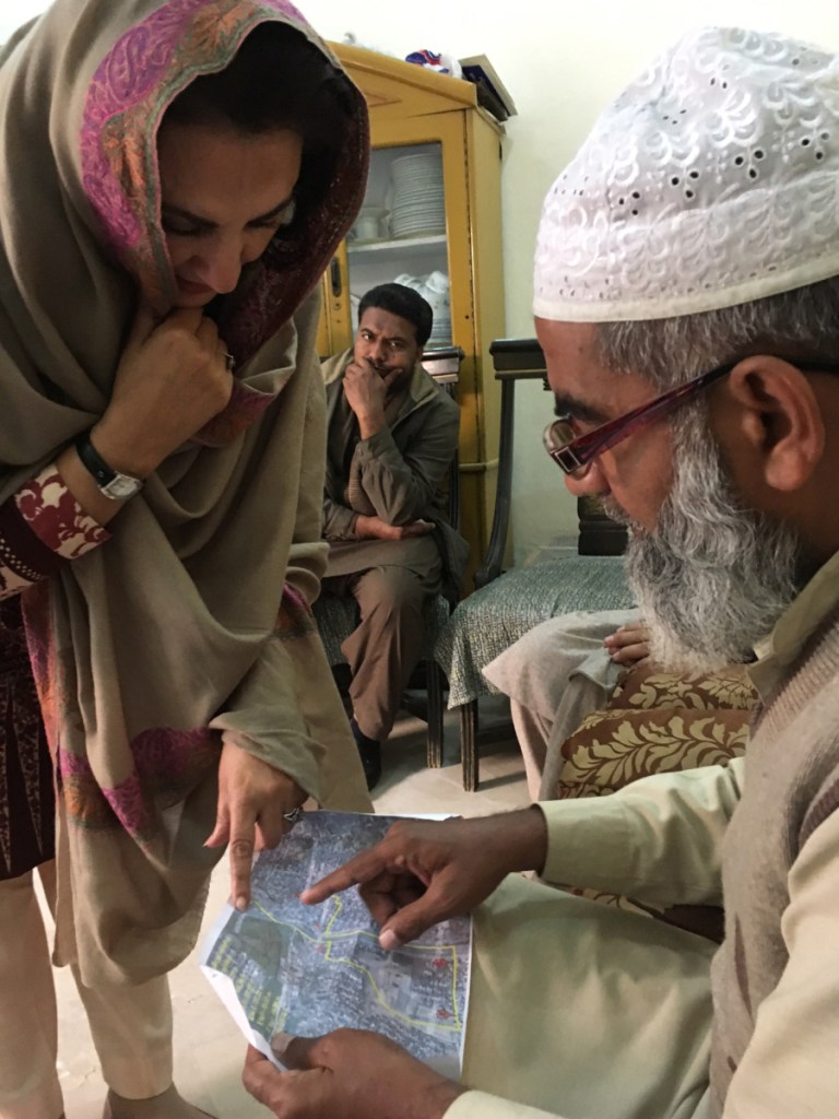 Muhammad Amin Ansari, right, the father of Zainab Amin, reviews a police map tracing the girl's last known movements before her brutal death.