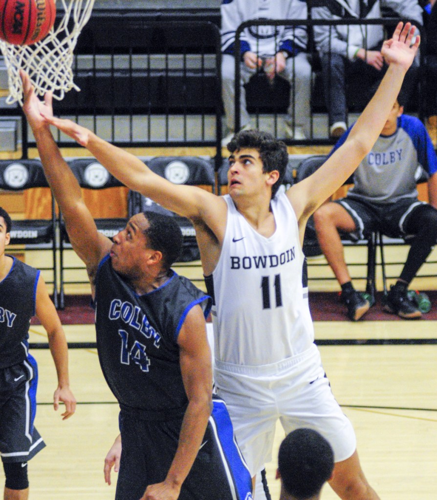 Colby's Steven Daley scoops a shot past the outstretched arm of Bowdoin's Sam Grad during their NESCAC basketball game Saturday in Brunswick. Bowdoin won, 83-77,