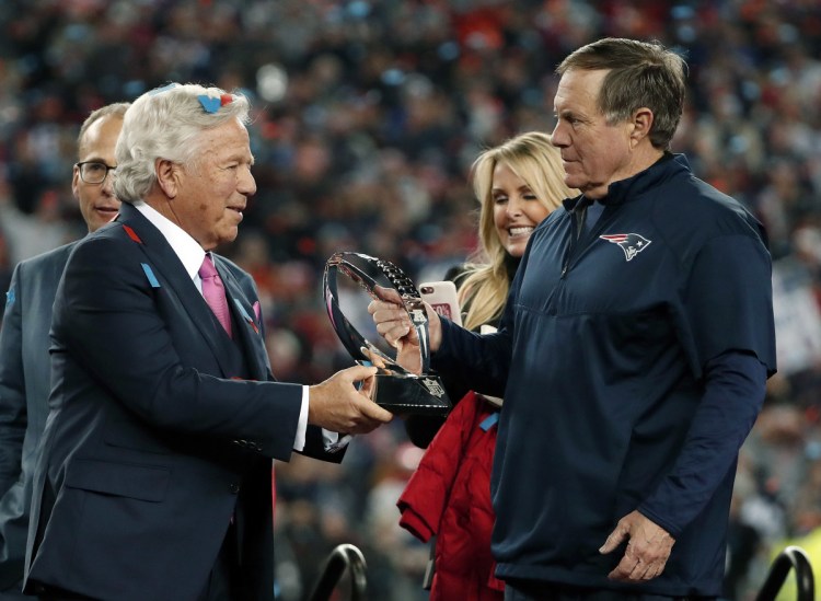 New England Patriots owner Robert Kraft, hands the trophy to head coach Bill Belichick after the AFC championship game against the Jacksonville Jaguars on Sunday in Foxborough, Mass. The Patriots won, 24-20.