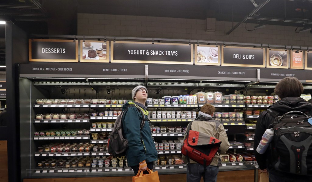 A customer shops in an Amazon Go store, where sensors and cameras are part of a system used to tell what people have purchased and charge their account.