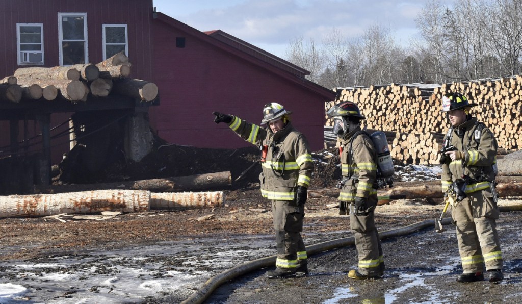 Firefighters convene at one end of the Hancock Lumber Co. sawmill building in Pittsfield, where fire was reported Sunday.