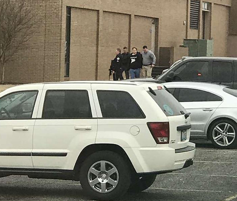 Police escort a person, second from right, out of the Marshall County High School after shooting there Tuesday in Benton, Kentucky. It's the nation's first fatal school shooting of 2018.