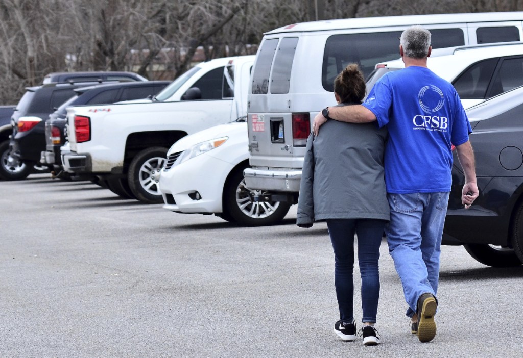 Family members escort their children out of Marshall North Middle School near Palma, Kentucky, on Tuesday after the students were taken there from Marshall County High School to be picked up by family members after a shooting.