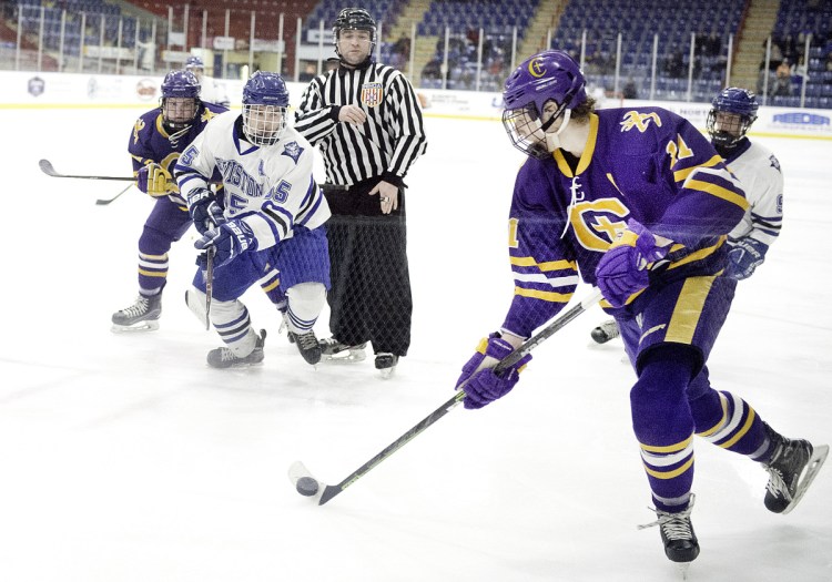 Marco Giancotti of Cheverus controls the puck following a faceoff between Lewiston's Sam Frechette and Justin Ray of Cheverus during Wednesday's game in Lewiston. Cheverus won, 2-1.