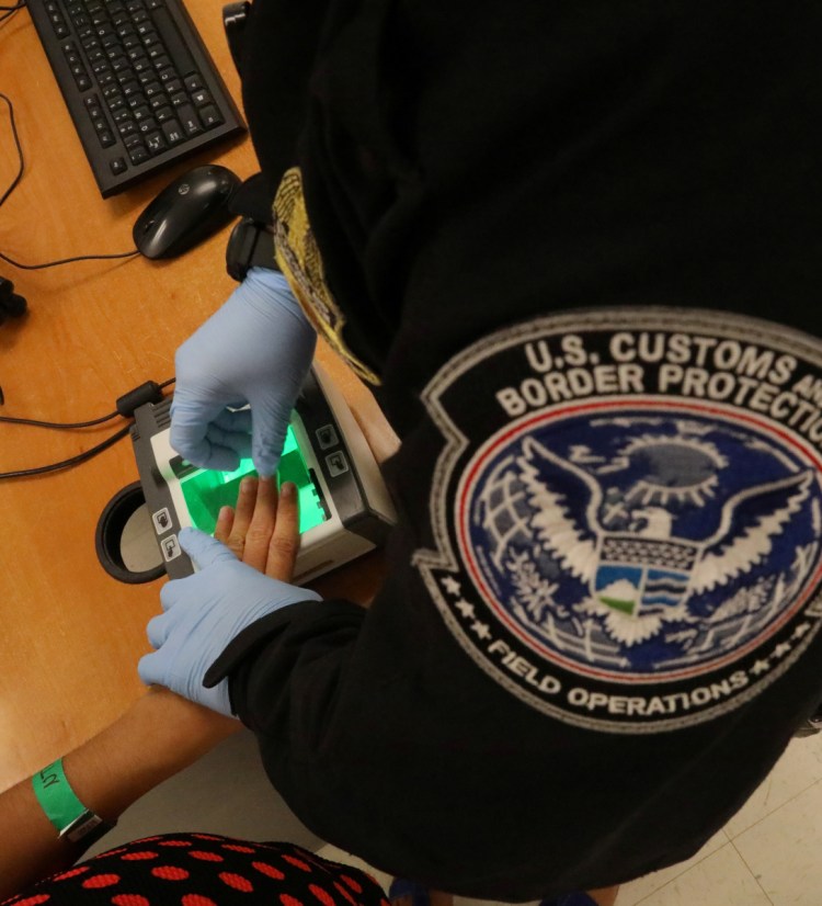 A woman who is seeking asylum has her fingerprints taken by a U.S. Customs and Border Protection officer in McAllen, Texas, last May. A law student in Portland says all is not dark in immigrants' fight.