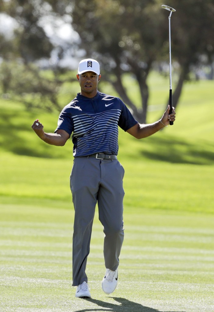 Tiger Woods reacts Friday after sinking a birdie putt on the first hole of the second round of the Farmers Insurance Open in San Diego. Woods shot a 71 to make the cut but is 10 shots out of the lead.