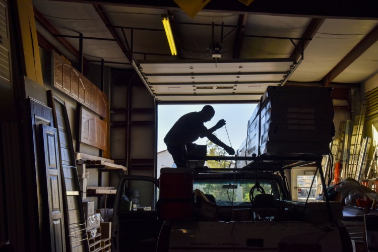 Ian Black loads a truck in preparation for a day of installing garage doors for Pioneer Overhead Door in Las Vegas. A convicted burglar, he spends his nights in a work-release facility and works at Pioneer by day. 