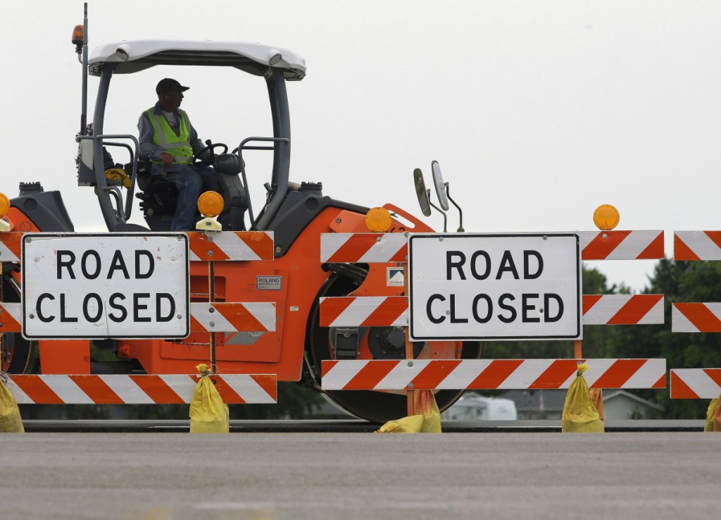 Construction crews work on a road in Edinburg, Ill., in 2016. President Trump is proposing to streamline environmental review of infrastructure projects.