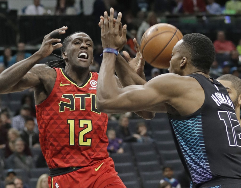 Atlanta's Taurean Prince is fouled as he drives against Charlotte's Dwight Howard in the first half Friday night in Charlotte, N.C. The Hornets won 121-110.