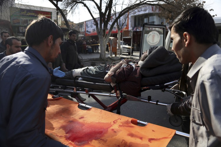 An injured man is moved onto a stretcher outside a hospital after a suicide attack in Kabul, Afghanistan, on Saturday. 