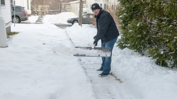 Deputy Police Chief Jared Mills shovels a walkway Thursday on Crosby Street in Augusta as part of the new Clear Paths and Connected Community volunteer program.